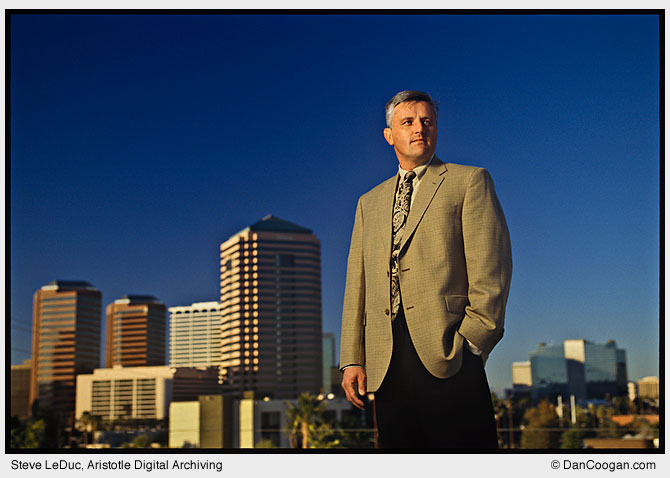 Steve LeDuc, Aristotle Digital Archiving, stands atop a building with the Phoenix skyline in the background